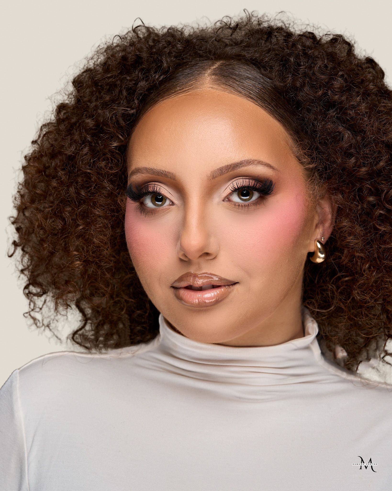 Soft studio glam with fluttered lashes and a warm flush