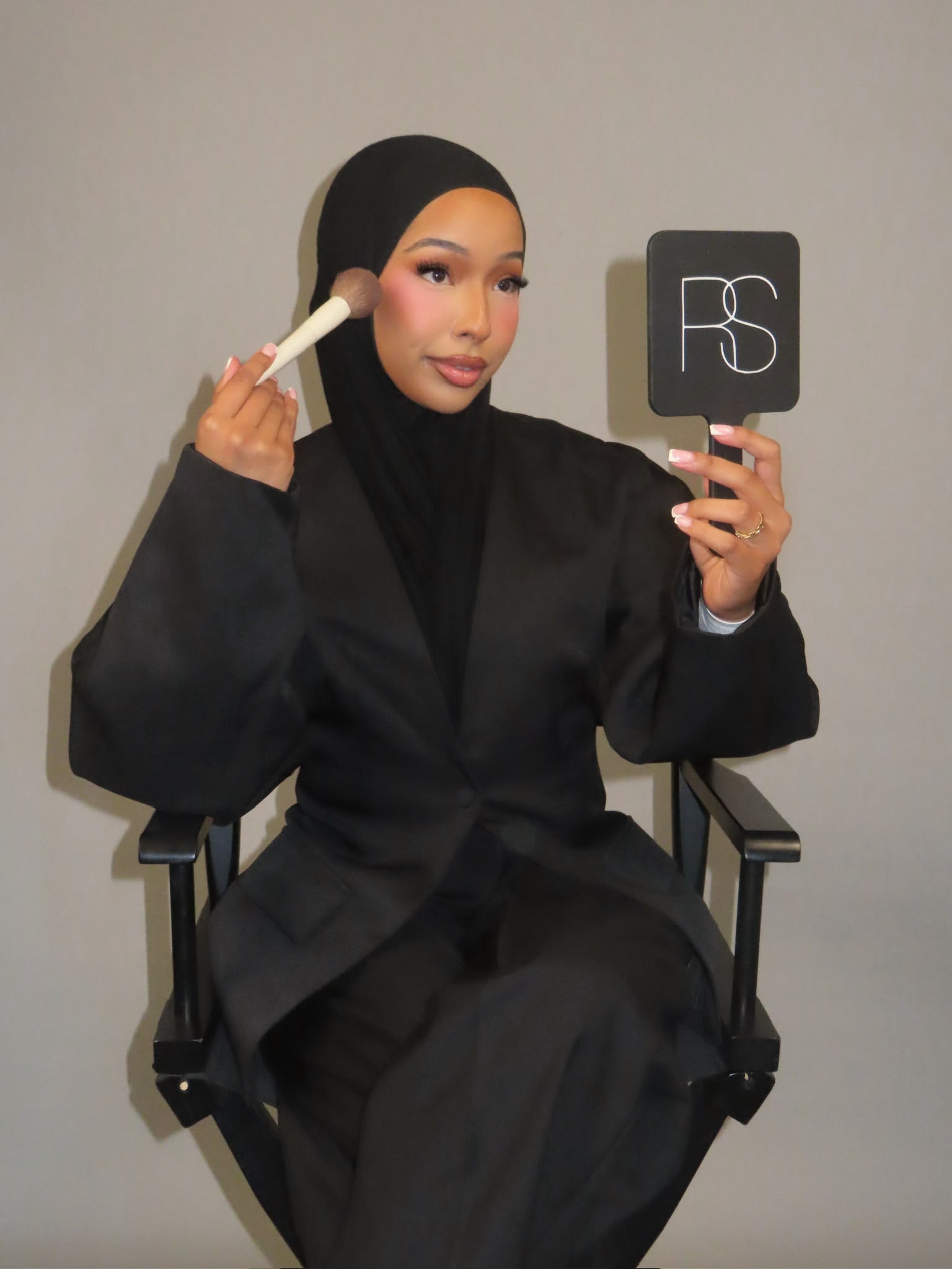 Portrait of Silvia, founder of RS Artistry, holding an RS Artistry hand mirror